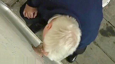 Grey old moustached man giving blowjob through glory hole